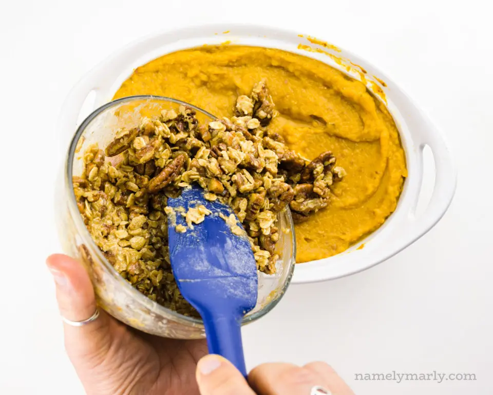 Pouring crumble topping over the sweet potato casserole.
