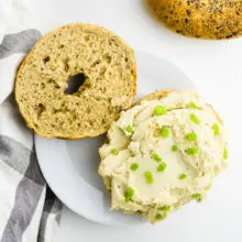 One of a bagel has vegan cream cheese smeared over the top.