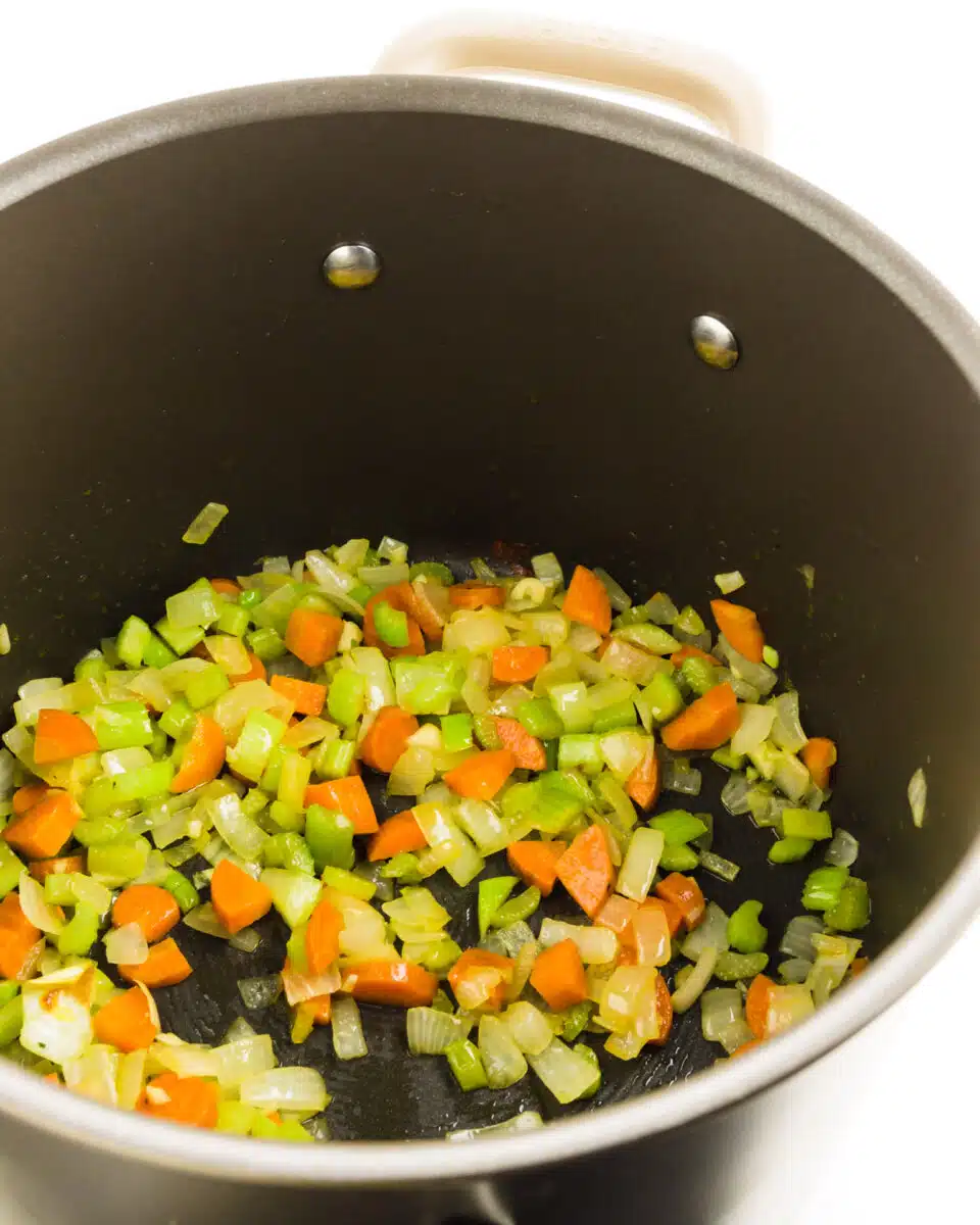 Looking into a pot full of chopped onions, carrots, and celery. 