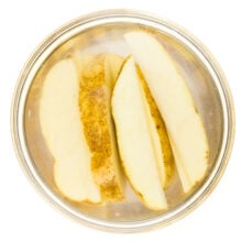 Potato wedges in a bowl of water, soaking before being cooked.