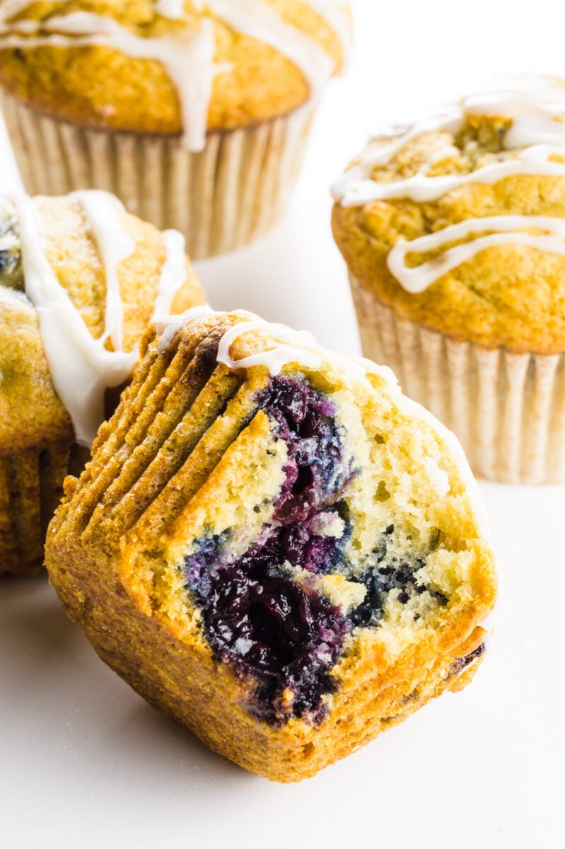 A cherry muffin with a bite taken out of it sits in front of other muffins.