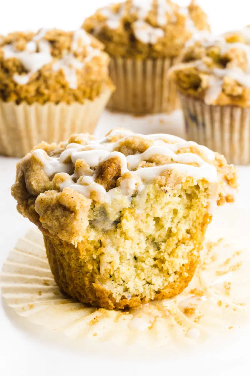A cinnamon muffin with a bite take out sits in front of other muffins.