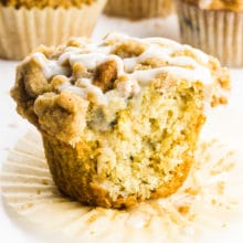 A cinnamon muffin has a bite taken out.