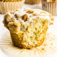A cinnamon muffin has a bite taken out.