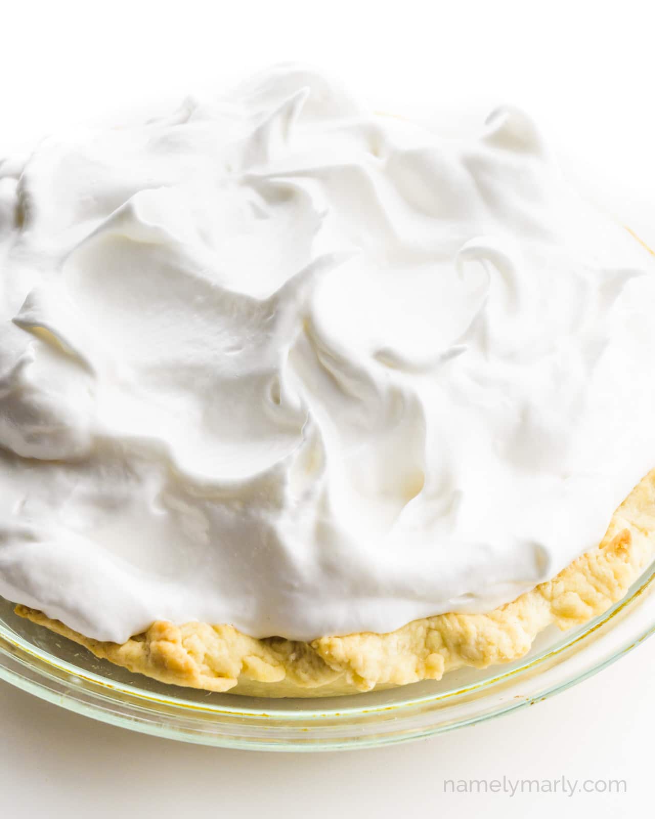A lemon pie is topped with unbaked meringue.