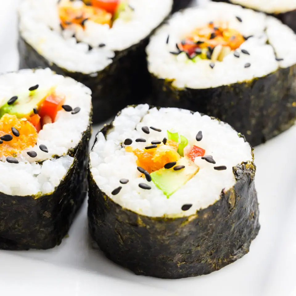 Looking closely at several rolls of vegan sushi.