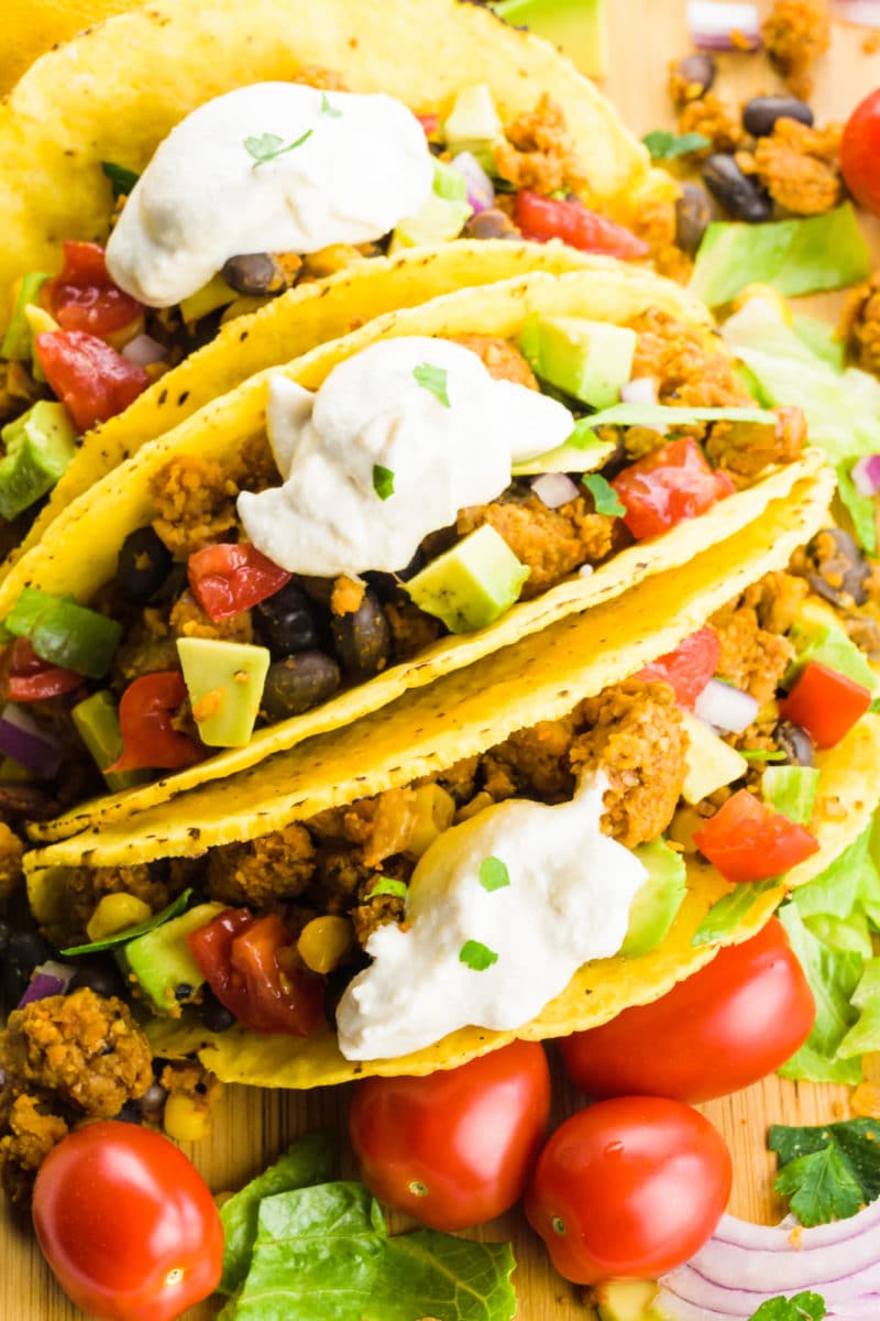 Several soft tacos have cashew cream on top.