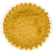 An oatmeal pie crust fresh from the oven sits on a white table.