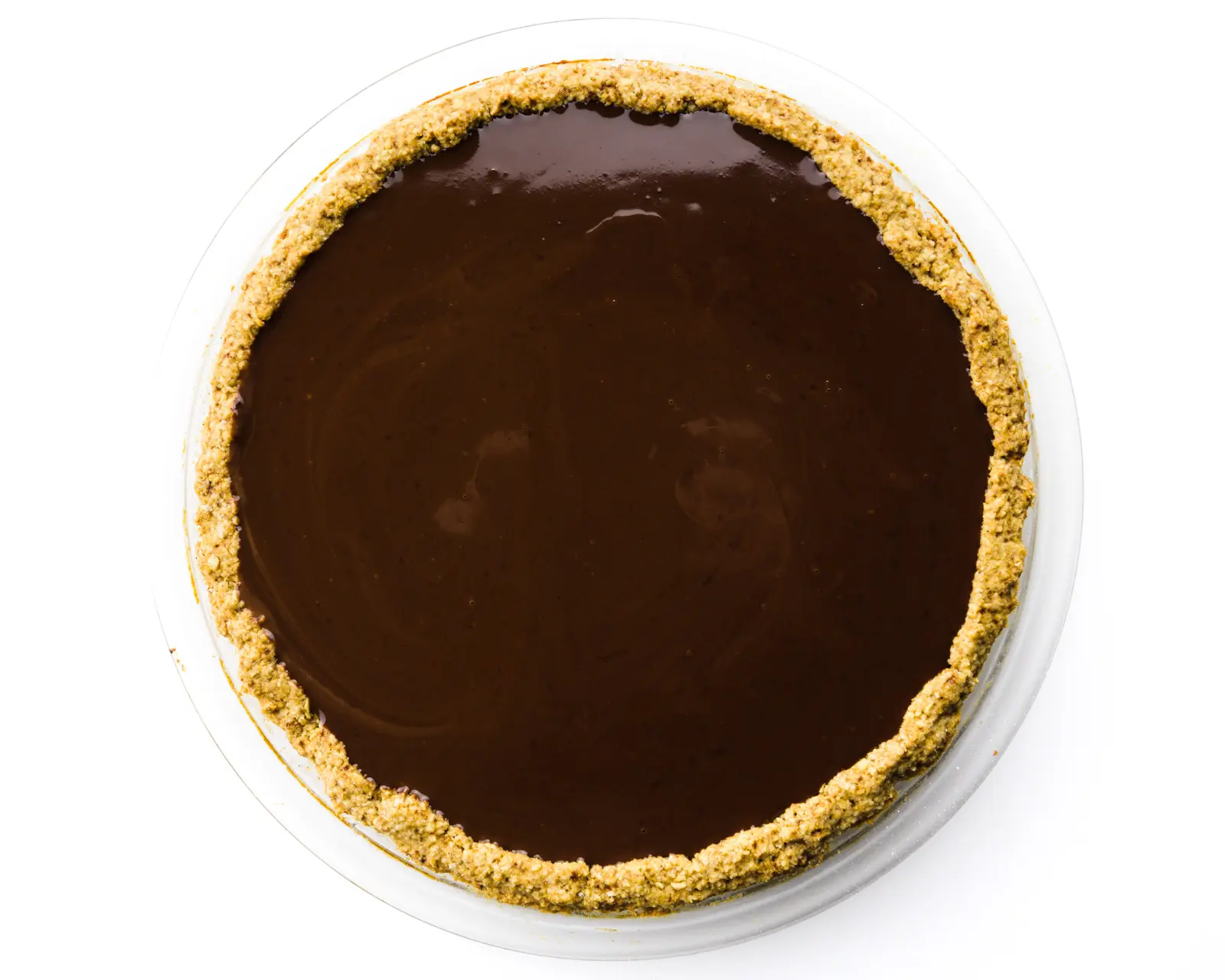 Looking down on a full chocolate pie sitting in an oatmeal pie crust.
