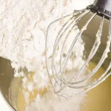 A flour mixture is being poured in with cake batter.