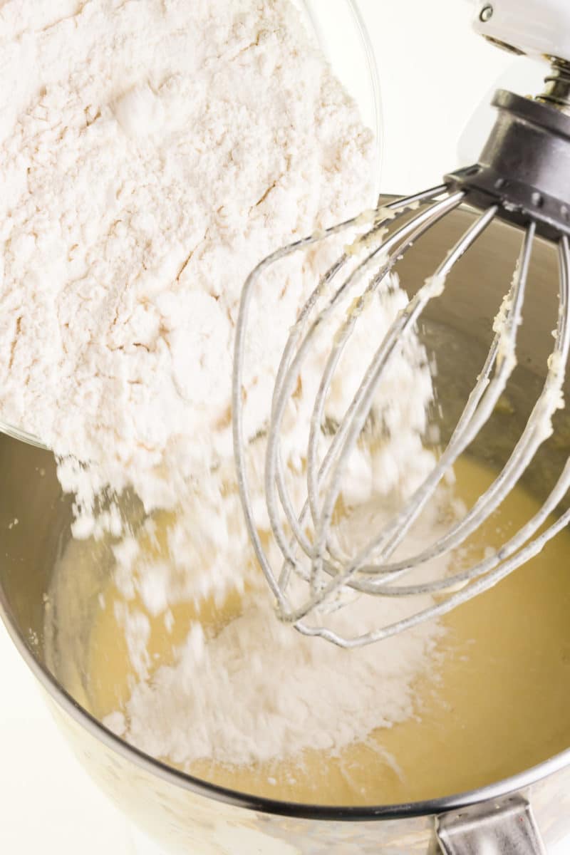 A flour mixture is being poured in with cake batter.