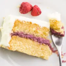 Looking down on a slice of cake on a plate. A fork has taken a bite out and is sitting next to the cake.
