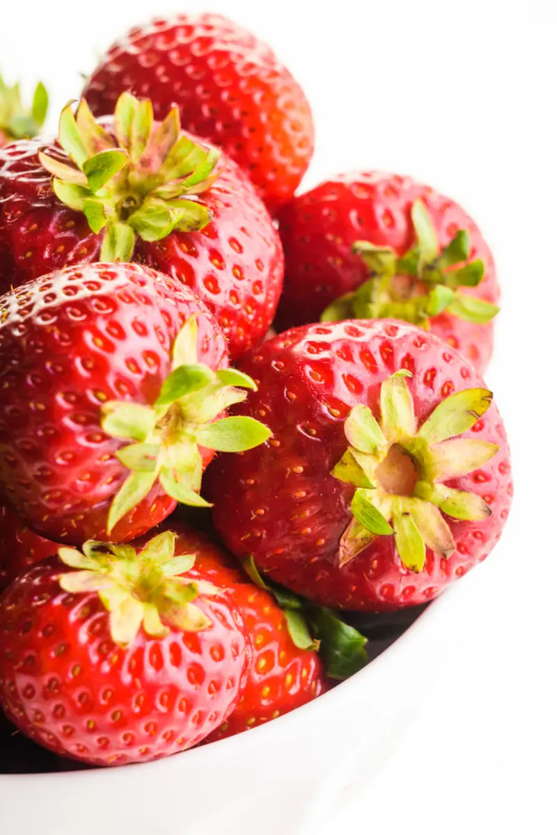 A bowl holds several fresh strawberries.