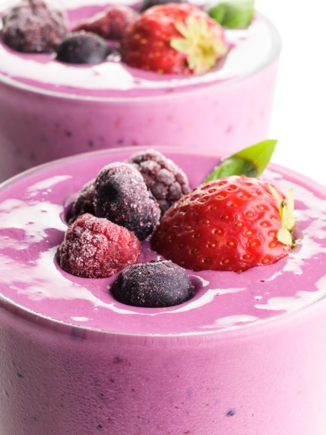 A close-up shot showing the tops of two glasses full of berry smoothies, with berries right on top!
