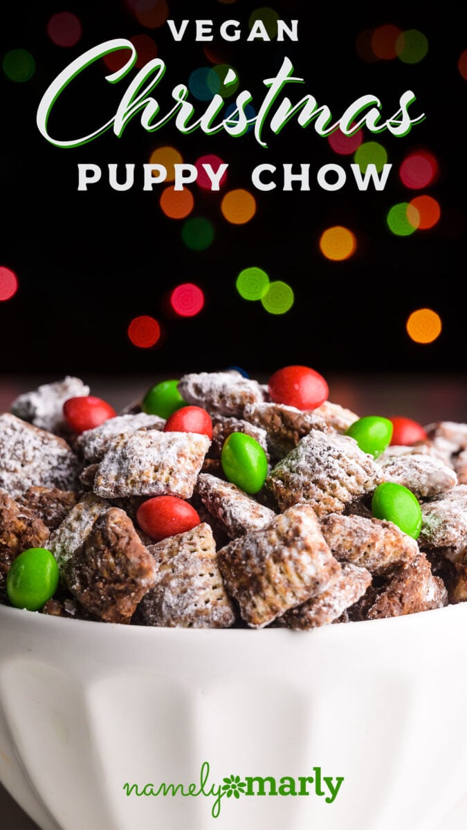 A bowl of candy coated Chex mix has christmas lights shining overhead. The text reads, Vegan Christmas Puppy Chow.
