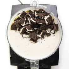 Looking down on a food processor full of a creamy mixture with crumbled Oreos.