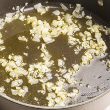 Onion is cooked until tender in a large pot.