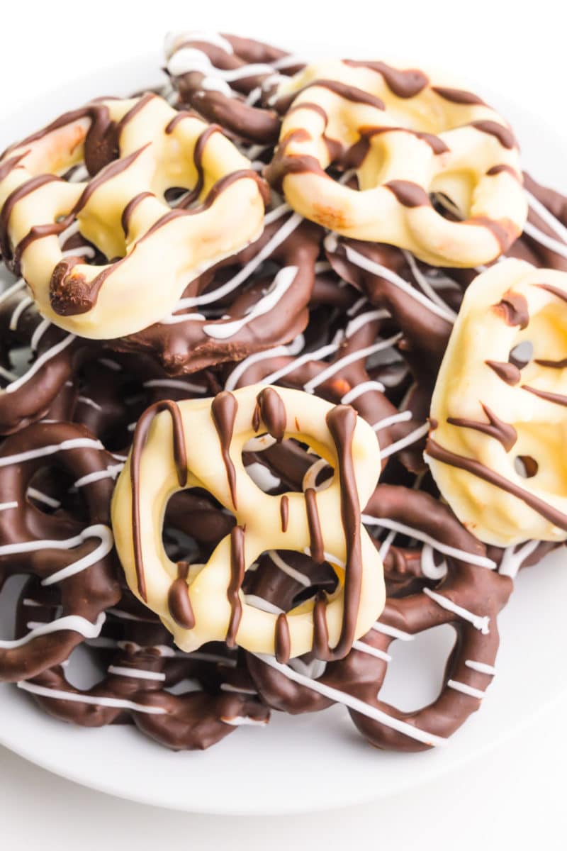 A plate holds dark and vegan white chocolate covered pretzels.