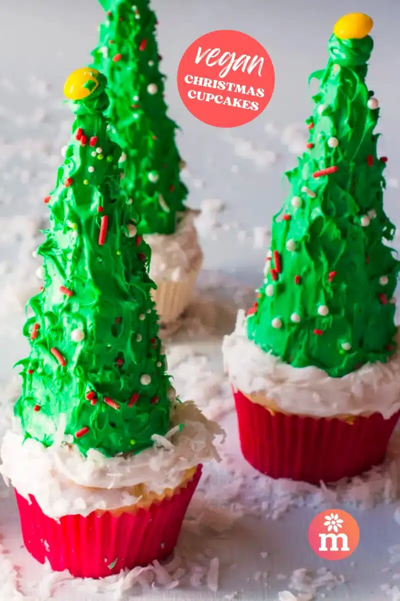 Three Christmas tree cupcakes sit on a grey table. The text reads, Vegan Christmas Cupcakes.