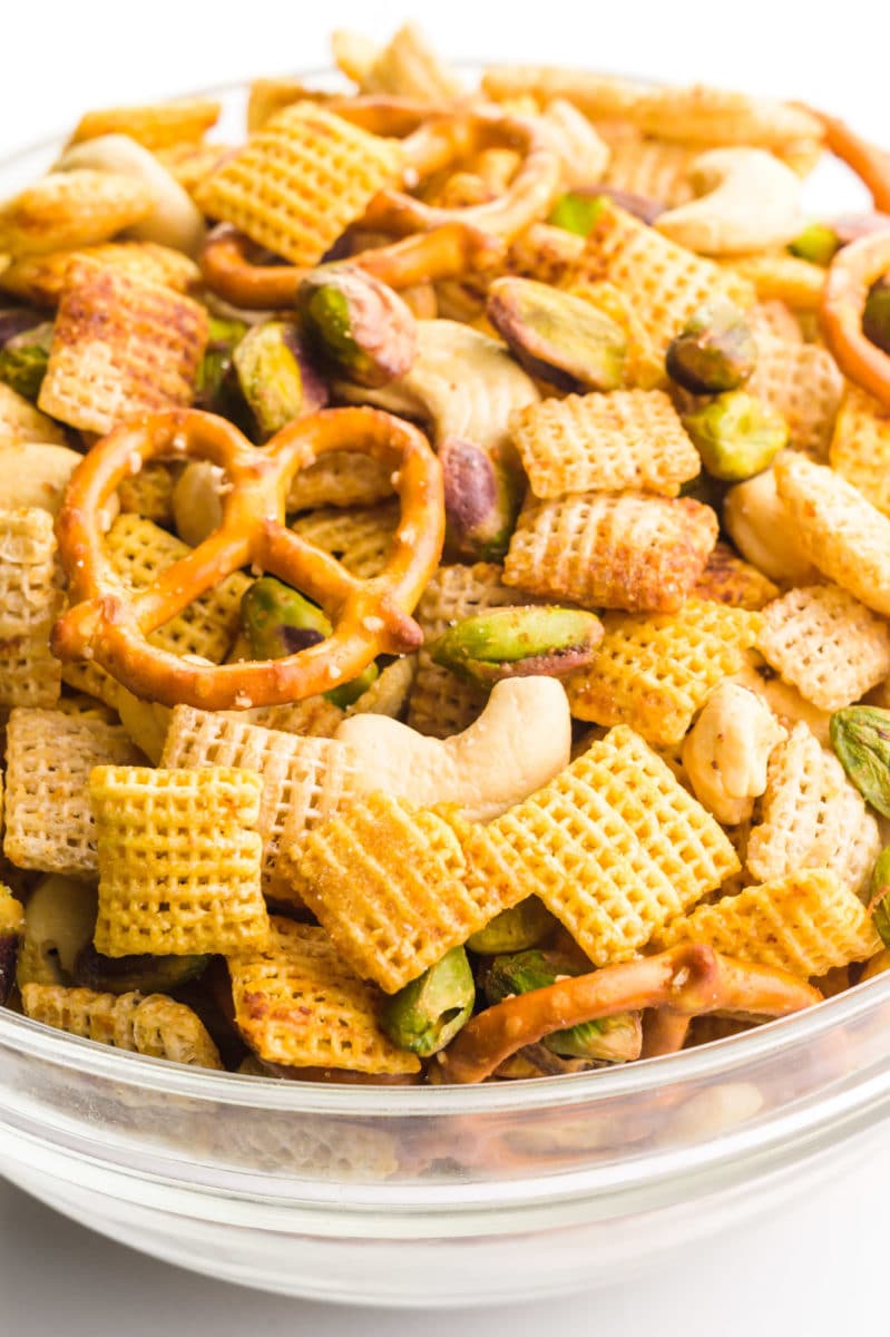 A large bowl holds Chex mix, with corn Chex, rice Chex, gluten-free pretzels, and nuts.