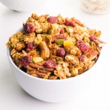 A bowl of peanut butter granola has dried cranberries, pumpkin seeds, nuts, and more.