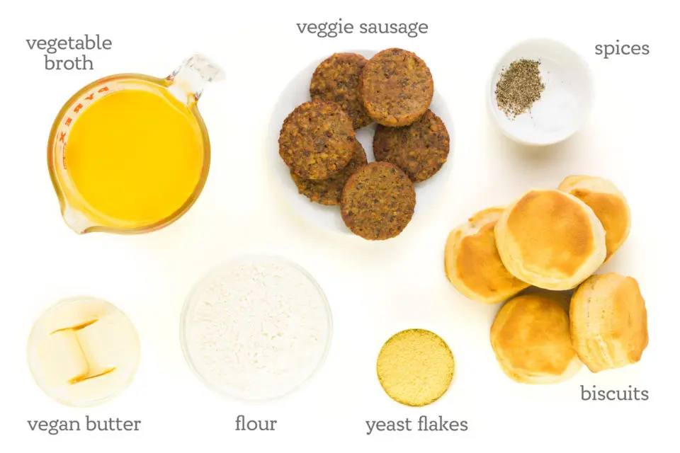 Ingredients are on a white counter top. The labels read, "Vegetable broth, Vegan Sausage, Salt and Pepper, Vegan Biscuits, Nutritional yeast, Flour, and Vegan Butter."
