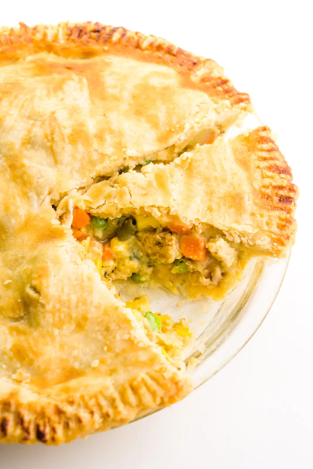 Looking down on a vegan pot pie with a slice cut out and another one cut and ready to be served.