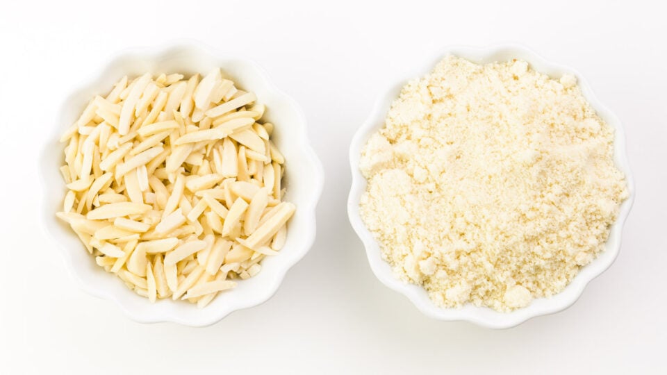 Looking down on two bowls, one with almond slivers and the other with almond flour.