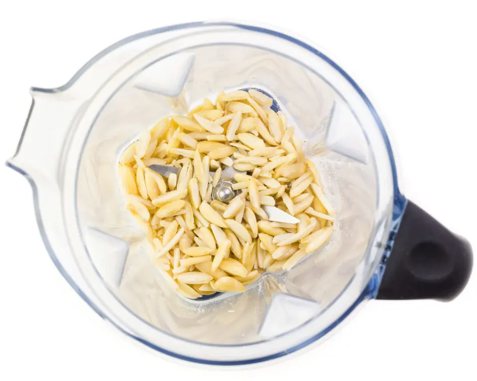Looking down on a blender with almond slivers in the bottom.