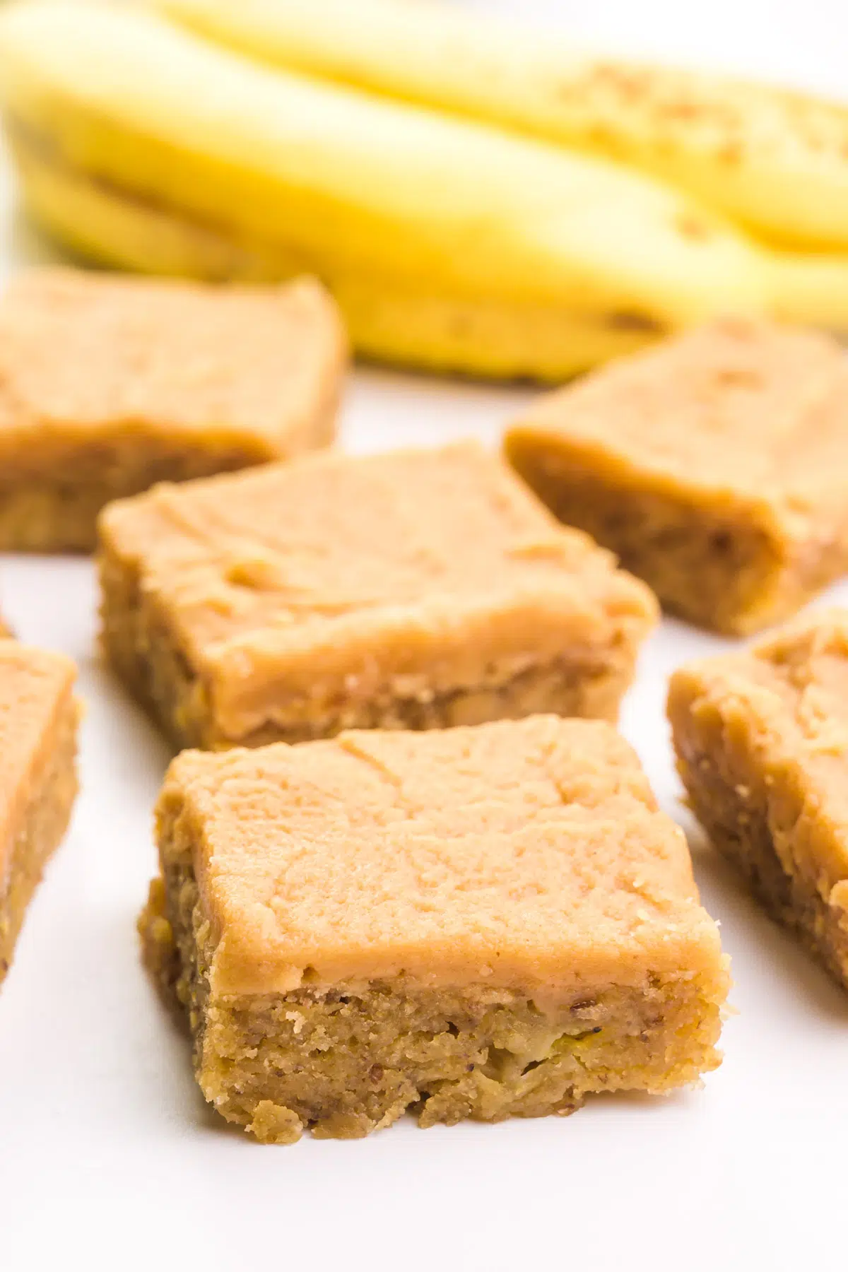 Slices of banana brownies sit in front of yellow bananas.