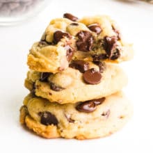 A stack of chocolate chip cookies shows the top with a bite taken out, revealing lots of melty chocolate chips.