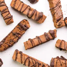 Biscotti cookies have been drizzled in chocolate and set on a pan to dry.