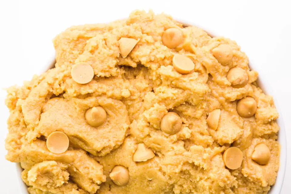 Looking down on a bowl full of cookie dough with peanut butter chips.