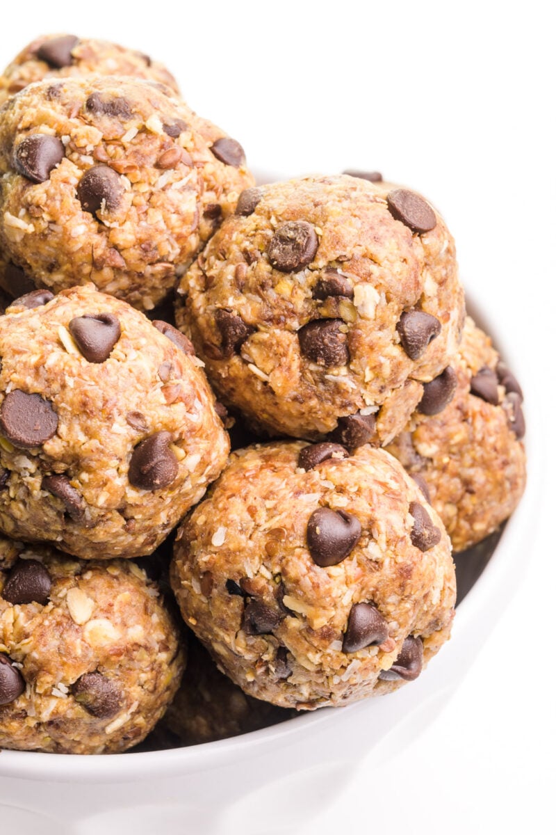 A bowl holds a mound of peanut butter energy bites with chocolate chips.