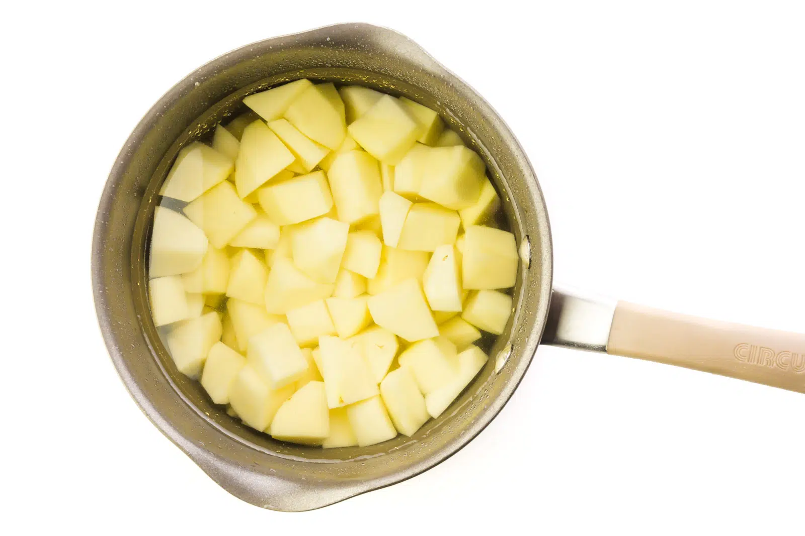 Peeled and chopped potatoes are in a saucepan.