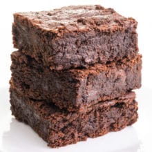 A stack of 3 black bean brownies sit on a plate.