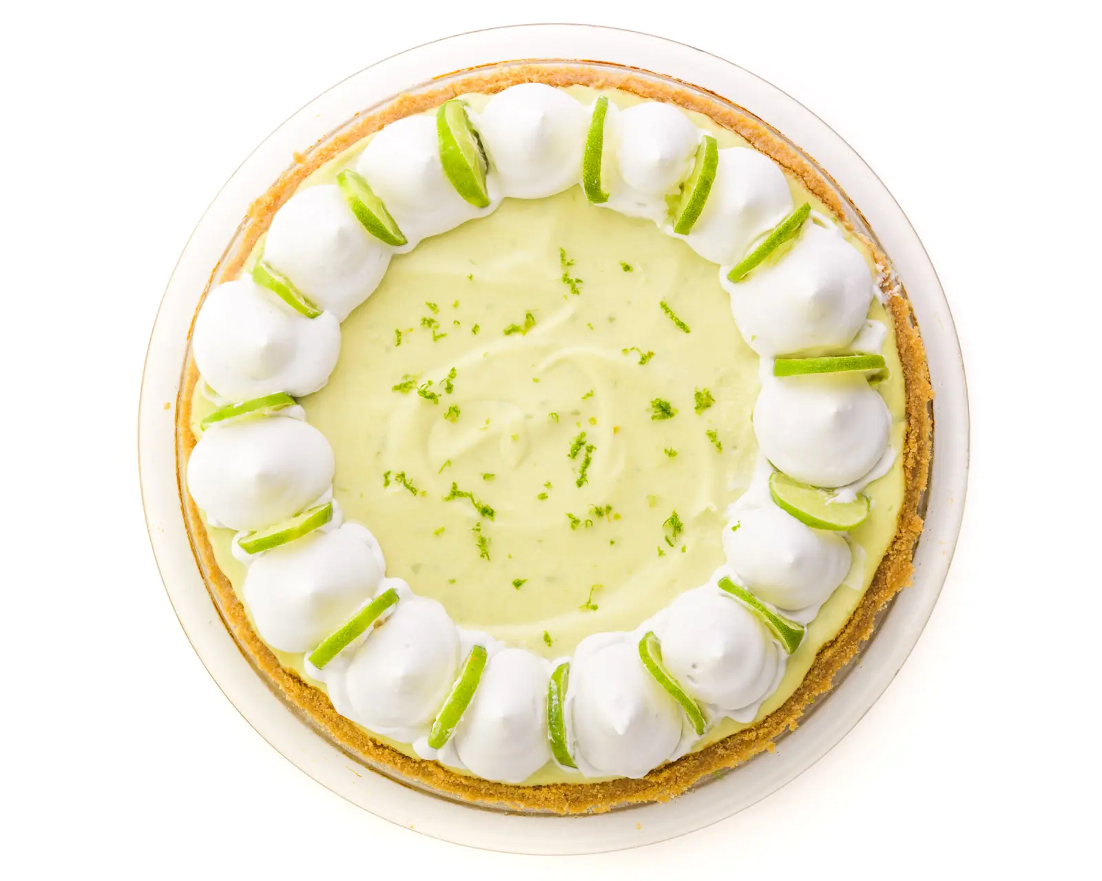 Looking down on a key lime pie with whipped cream dollops around the edges and lime slices.