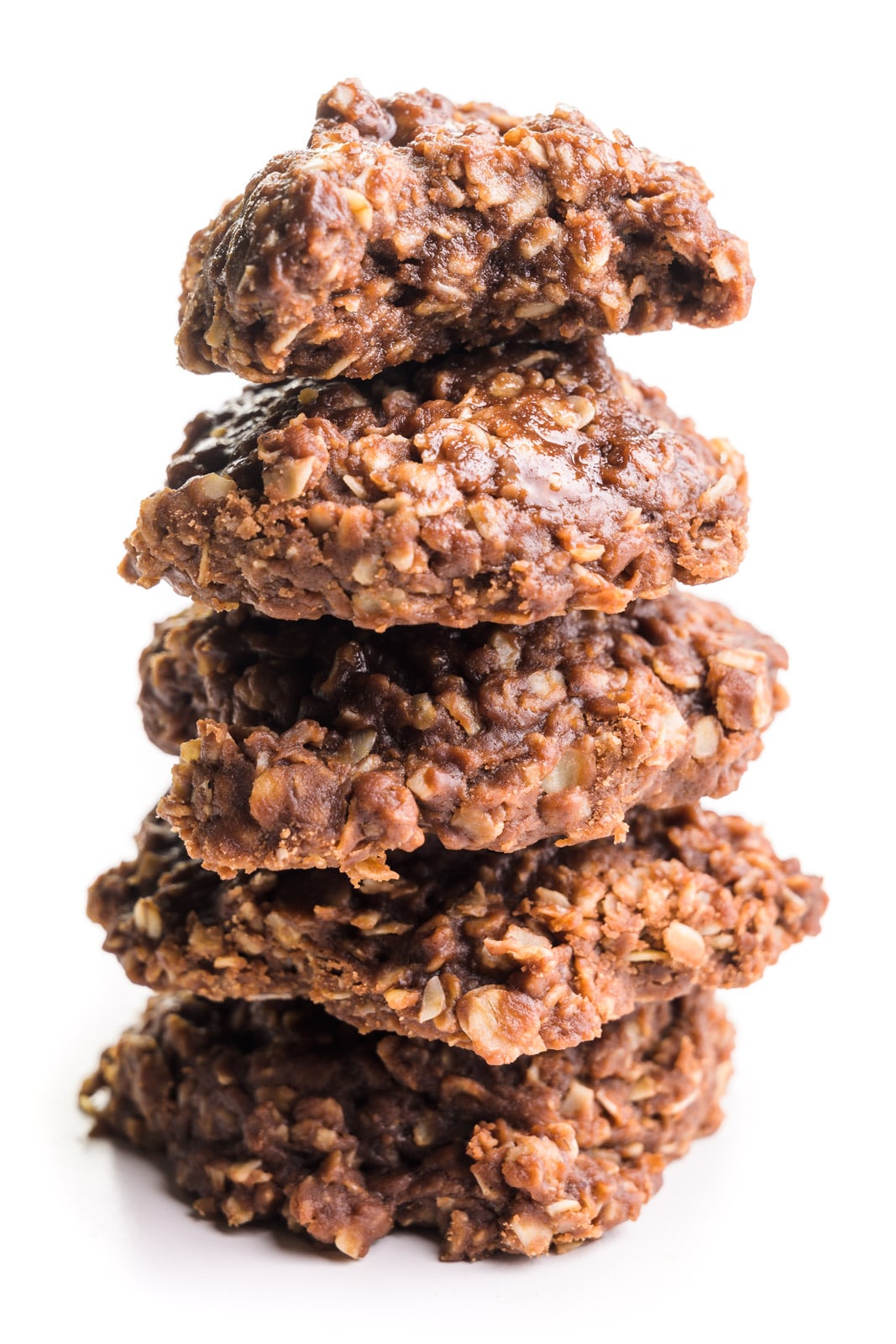 A stack of vegan no-bake cookies shows the top one with a bite taken out.