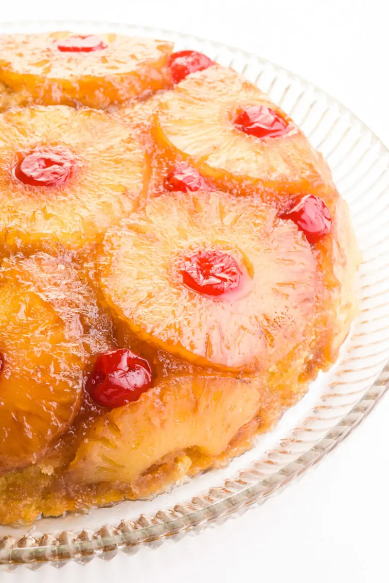 Looking down on a cake with pineapples and maraschino cherries on the outside.