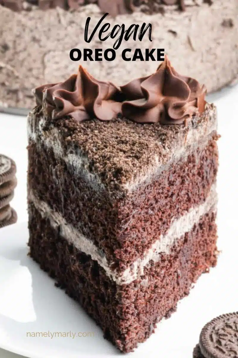 A slice of chocolate cake sits on a plate. The text reads, Vegan Oreo Cake.