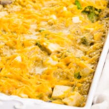 Tofu casserole is in a white baking dish. It has vegan cheddar cheese melted on top.