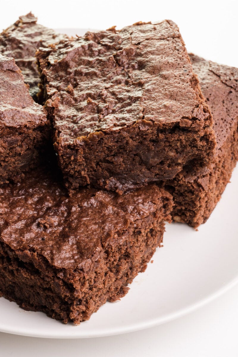 A plate of brownies sits on a white counter.