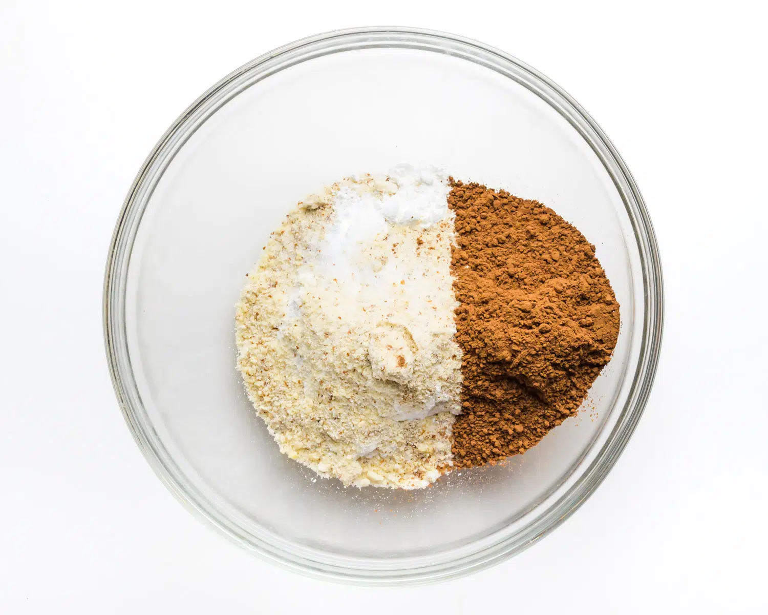 Dry ingredients are in a bowl, including cocoa powder, gluten-free flour, and more.