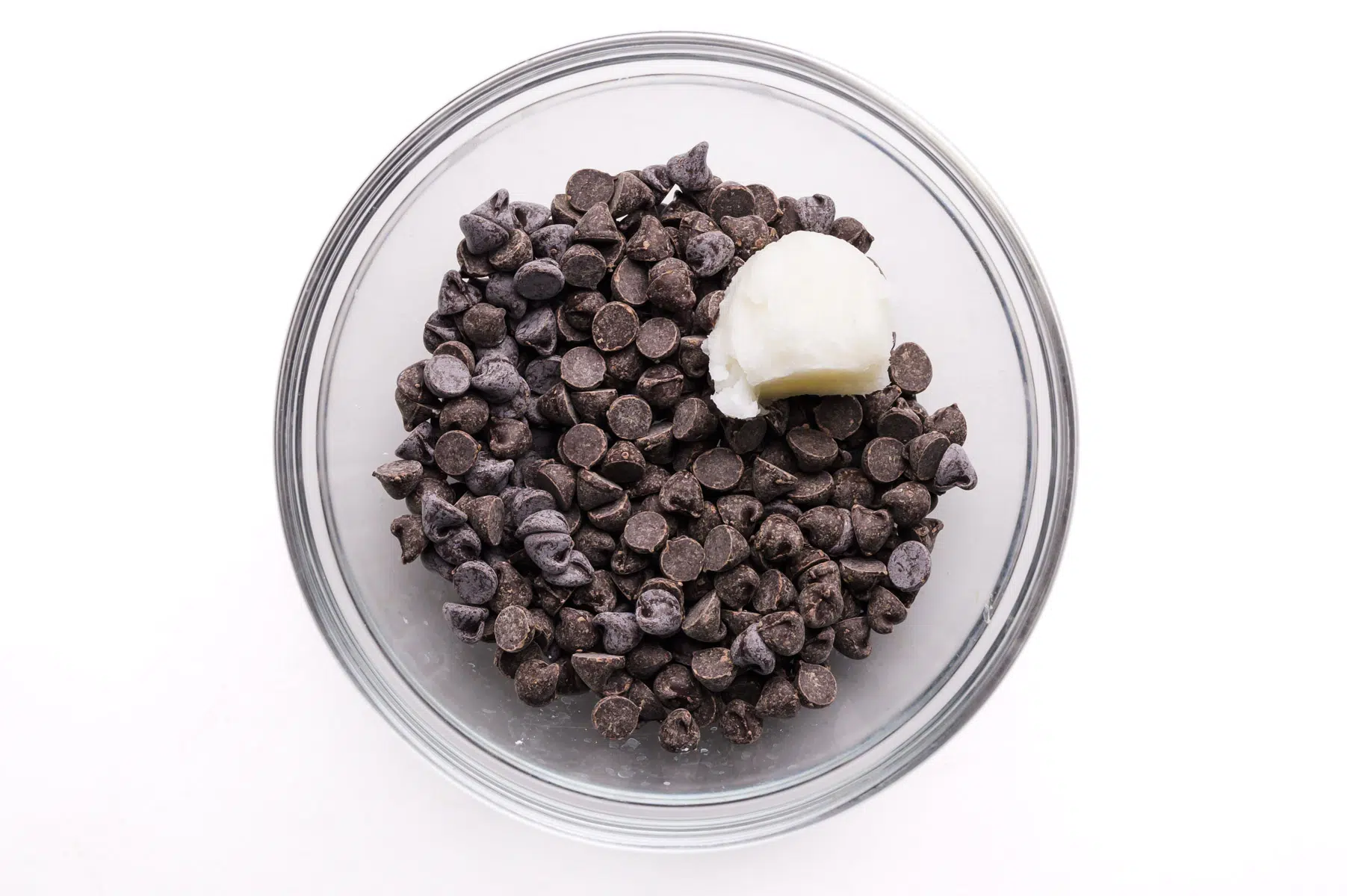 Chocolate chips and coconut oil are combined in a bowl.