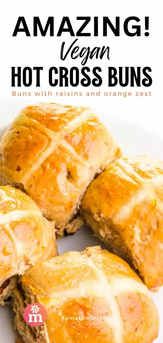 Orange-glazed buns on a plate. This text is on top, Amazing Vegan Hot Cross Buns.