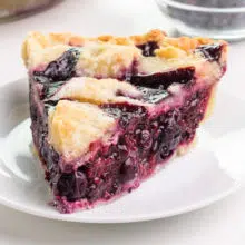 A slice of vegan berry pie sits on a plate.