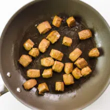 Vegan beef tips are being cooked in a skillet.