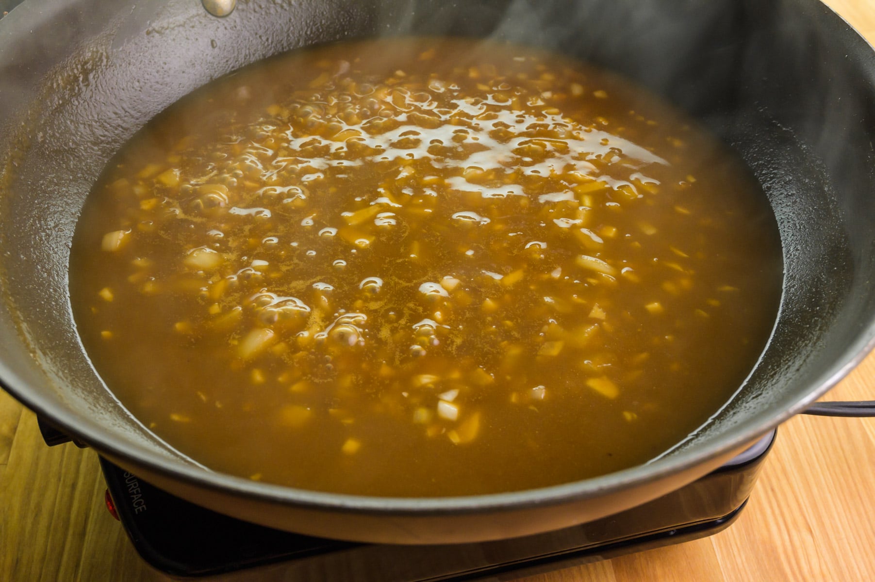 Sauce is being cooked in a skillet.