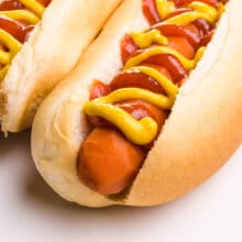 A carrot dog is in a bun and topped with ketchup and mustard.