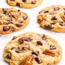 Chocolate chip pecan cookies are laid out on a white table.